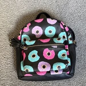 Donut Patterned Mini Backpack. Blue/Pink/Purple Donuts on Black. Tassel, Zip Pkt